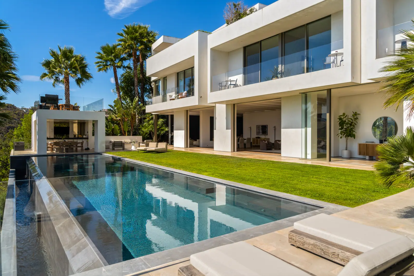 Infinity pool running the length of the house beside the lawn