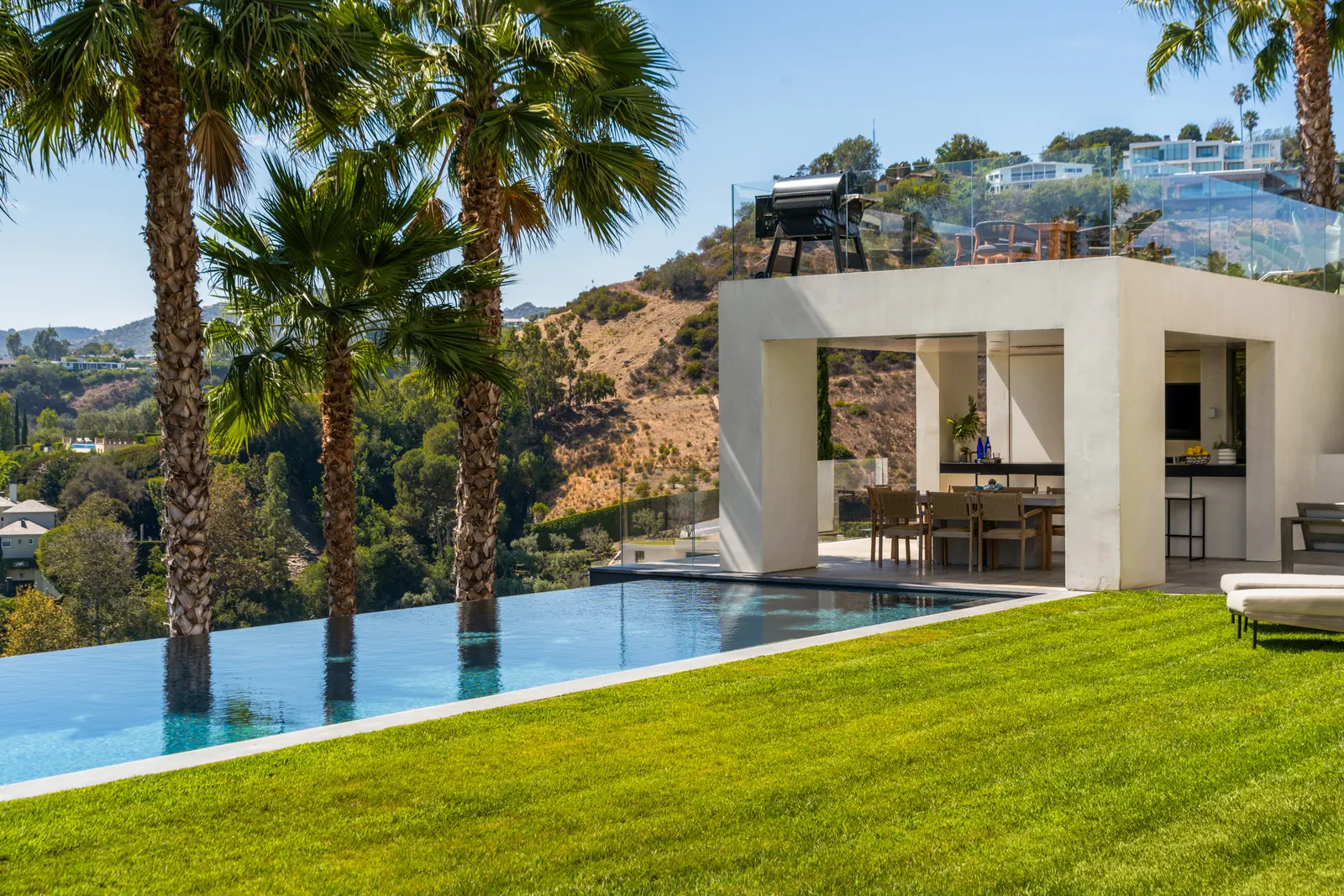 Open-air pavilion seen across the lawn from the pool