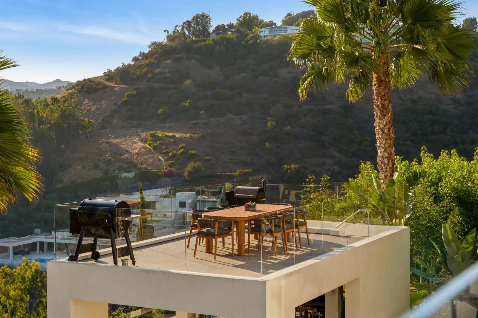 Roof terrace with dining table above the wooded canyon
